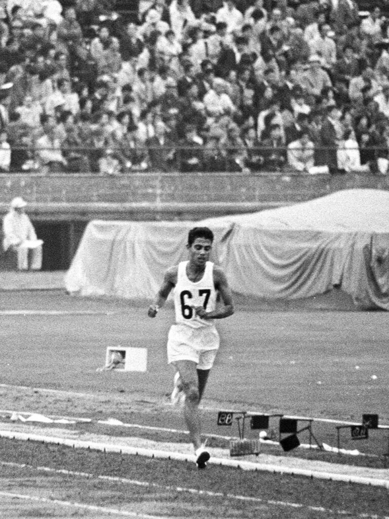 Ranatunge Karunananda from Crossing the Finish Line, running the 10,000m race at the 1964 Summer Olympics in Tokyo, Japan.